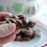 Holding one of my favorite slow cooker desserts, chocolate covered peanut clusters