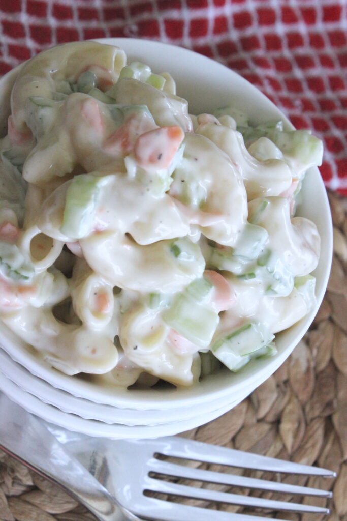 pasta side salad with carrots, celery, creamy sweet sauce and a fork to eat the pasta salad with