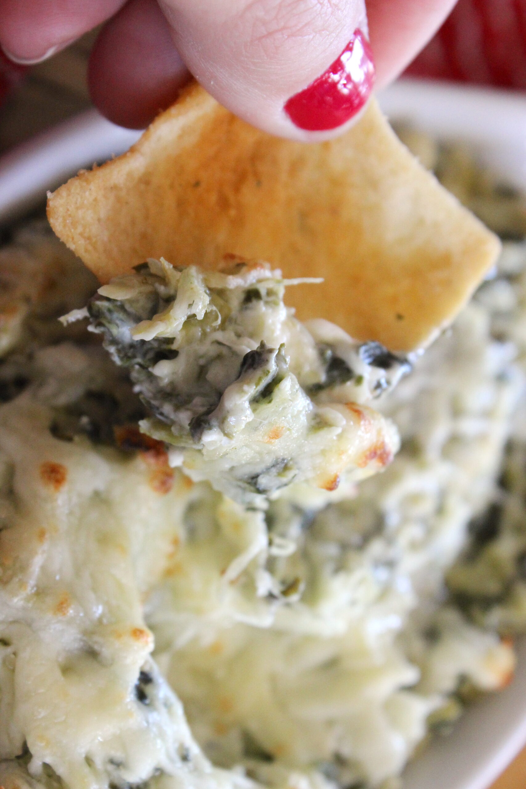 spinach and artichoke dip on a pita chip